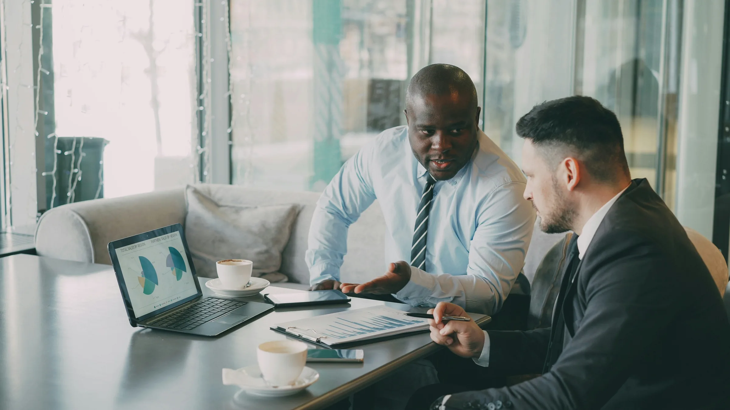 Two professionals reviewing financial information together at a meeting table