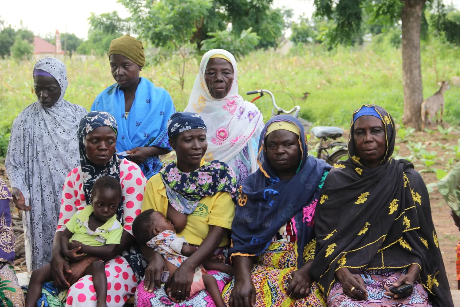 A seated group of women and children in a farming community